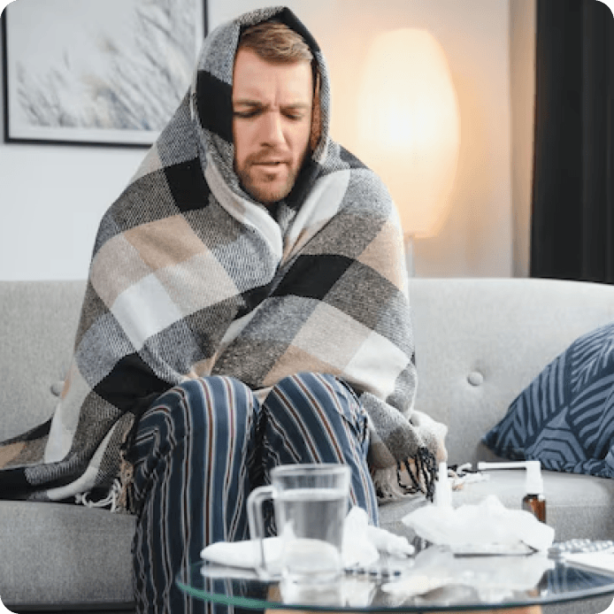 Osoba owinięta kocem, zmarznięta w domu